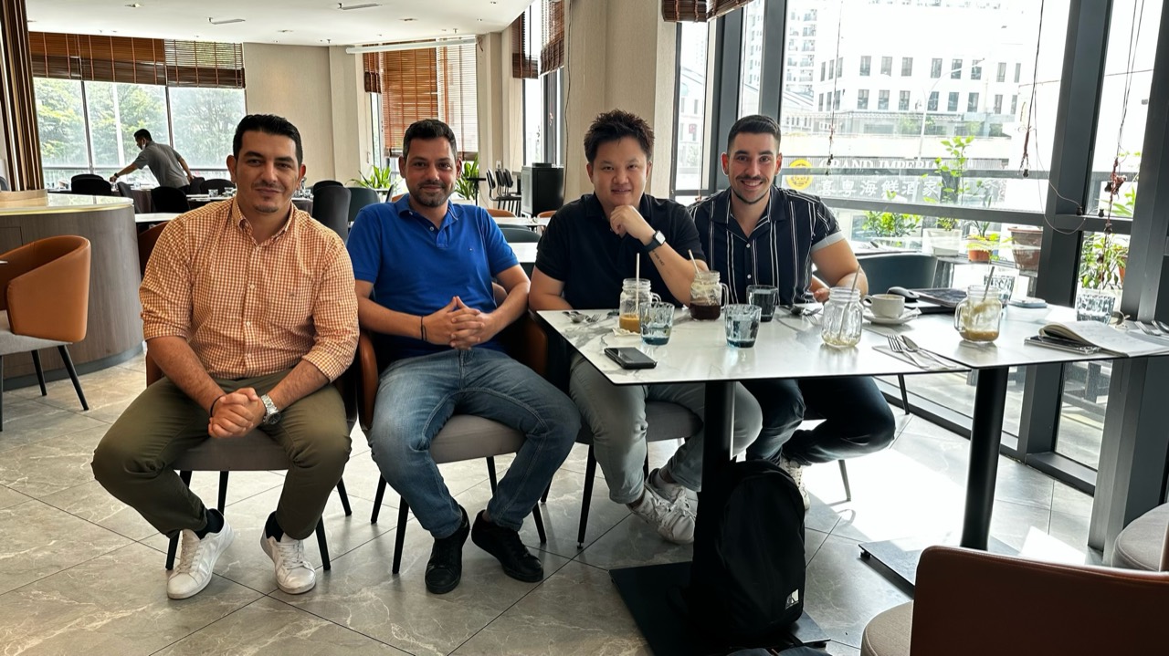 Lucas Loo seated with partners during a casual business meeting