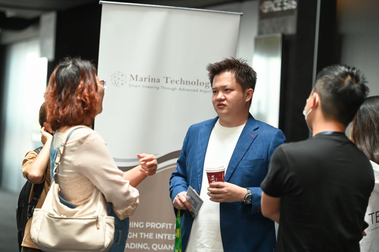 Lucas Loo discussing trading technology with attendees at an exhibition booth